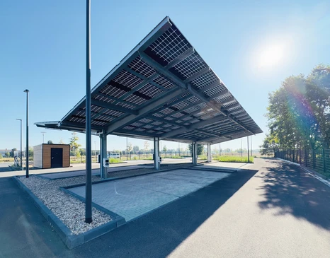 Parc solaire en pleine campagne sous ciel bleu nuageux avec soleil éclatant
